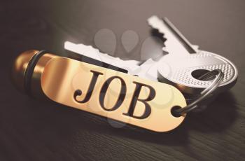 Keys and Golden Keyring with the Word Job over Black Wooden Table with Blur Effect. Toned Image.