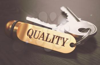 Keys to Quality - Concept on Golden Keychain over Black Wooden Background. Closeup View, Selective Focus, 3D Render. Toned Image.