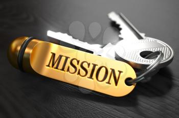 Keys with Word Mission on Golden Label over Black Wooden Background. Closeup View, Selective Focus, 3D Render.