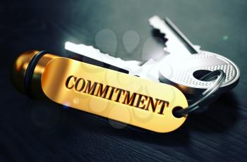Keys with Word Commitment on Golden Label over Black Wooden Background. Closeup View, Selective Focus, 3D Render. Toned Image.
