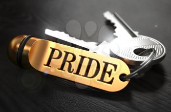 Keys and Golden Keyring with the Word Pride over Black Wooden Table with Blur Effect.