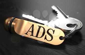 Keys with Word Ads on Golden Label over Black Wooden Background. Closeup View, Selective Focus, 3D Render.