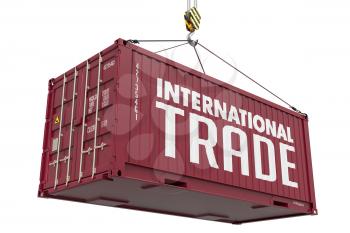 International Trade concept with a Metal Shipping Container Suspended from a Crane Hook.