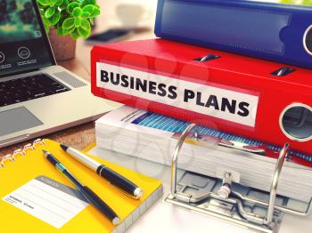 Business Plans - Red Office Folder on Background of Working Table with Stationery, Laptop and Reports. Business Concept on Blurred Background. Toned Image.