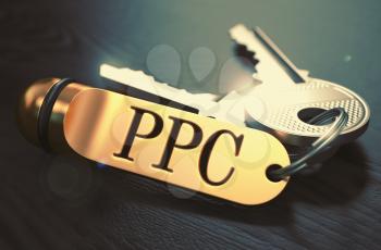 Keys and Golden Keyring with the Word PPC - Pay Per Click - over Black Wooden Table with Blur Effect. Toned Image.