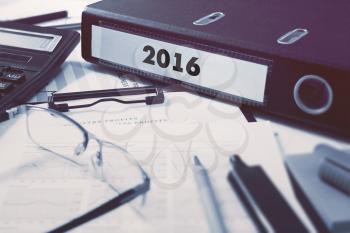 2016 - Ring Binder on Office Desktop with Office Supplies. Business Concept on Blurred Background. Toned Illustration.