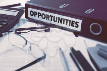 Opportunities - Office Folder on Background of Working Table with Stationery, Glasses, Reports. Business Concept on Blurred Background. Toned Image.