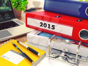 2015 - Red Office Folder on Background of Working Table with Stationery, Laptop and Reports. Business Concept on Blurred Background. Toned Image.