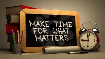 Make Time for What Matters - Chalkboard with Hand Drawn Text, Stack of Books, Alarm Clock and Rolls of Paper on Blurred Background. Toned Image.