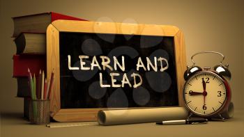 Learn and Lead Concept Hand Drawn on Chalkboard. Blurred Background. Toned Image.