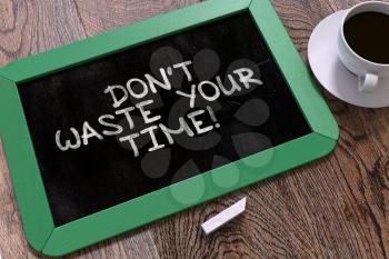 Don't Waste Your Time - Motivational Quote Hand Drawn on Green Chalkboard on Wooden Table. Business Background. Top View.