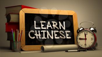 Learn Chinese - Chalkboard with Hand Drawn Text, Stack of Books, Alarm Clock and Rolls of Paper on Blurred Background. Motivational Quote. Toned Image.