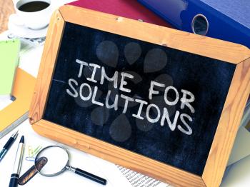 Time for Solutions - Chalkboard with Hand Drawn Text, Stack of Office Folders, Stationery, Reports on Blurred Background. Toned Image. Motivational Quote.