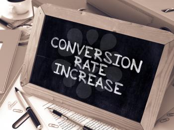 Conversion Rate Increase - Chalkboard with Hand Drawn Text, Stack of Office Folders, Stationery, Reports on Blurred Background. Toned Image.