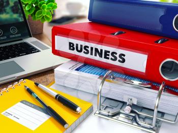 Business - Red Ring Binder on Office Desktop with Office Supplies and Modern Laptop. Business Concept on Blurred Background. Toned Illustration.