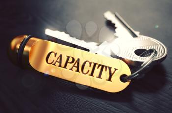 Keys with Word Capacity on Golden Label over Black Wooden Background. Closeup View, Selective Focus, 3D Render. Toned Image.