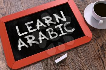 Learn Arabic Concept Hand Drawn on Red Chalkboard on Wooden Table. Business Background. Top View.
