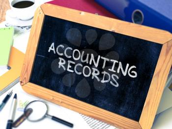 Accounting Records - Chalkboard with Hand Drawn Text, Stack of Office Folders, Stationery, Reports on Blurred Background. Toned Image.