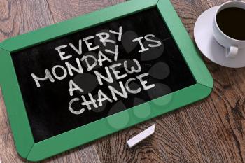 Every Monday is a New Chance. Inspirational Quote Hand Drawn on Green Chalkboard on Wooden Table. Business Background. Top View.