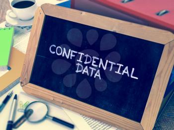 Confidential Data - Chalkboard with Hand Drawn Text, Stack of Office Folders, Stationery, Reports on Blurred Background. Toned Image.