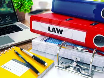 Law - Red Ring Binder on Office Desktop with Office Supplies and Modern Laptop. Business Concept on Blurred Background. Toned Illustration.