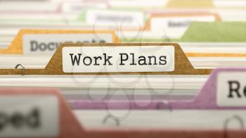 File Folder Labeled as Work Plans in Multicolor Archive. Closeup View. Blurred Image.