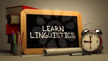 Hand Drawn Learn Linguistics Concept  on Chalkboard. Blurred Background. Toned Image.