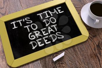 It's Time to Do Great Deeds - Yellow Chalkboard with Hand Drawn Motivation Quote and White Cup of Coffee on Wooden Table. Top View.