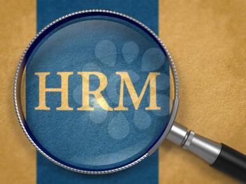 HRM - Human Resources Management - through Magnifying Glass on Old Paper with Dark Blue Vertical Line Background.