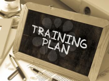 Training Plan Concept Hand Drawn on Chalkboard on Working Table Background. Blurred Background. Toned Image.