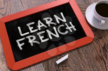 Learn French Concept Hand Drawn on Red Chalkboard on Wooden Table. Business Background. Top View. 3d Render.
