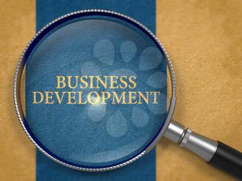 Business Development through Loupe on Old Paper with Dark Blue Vertical Line Background. 3d Render.