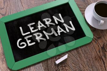 Hand Drawn Learn German Concept  on Small Green Chalkboard. Business Background. Top View. 3d Render.