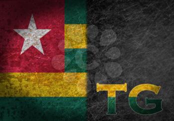 Old rusty metal sign with a flag and country abbreviation - Togo
