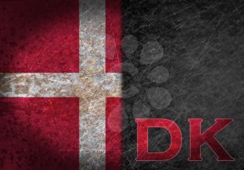 Old rusty metal sign with a flag and country abbreviation - Denmark