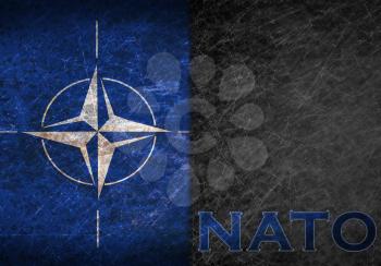 Old rusty metal sign with a NATO flag and abbreviation