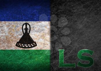 Old rusty metal sign with a flag and country abbreviation - Lesotho