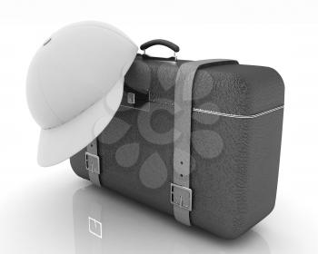 Brown traveler's suitcase and peaked cap on a white background
