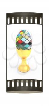 Easter egg on gold egg cups on a white background. The film strip