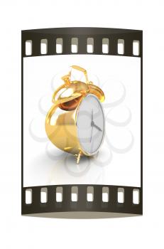 Gold alarm clock on a white background. The film strip