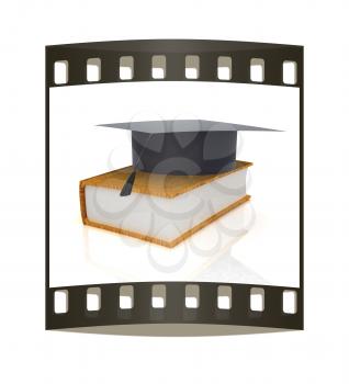 Graduation hat on a leather book on a white background. The film strip