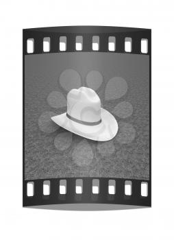 White hat with a red ribbon on a green grass background. 3d. The film strip