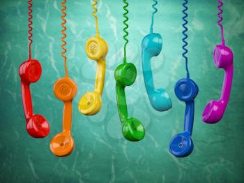 Telehone receivers of different colors hanging on the green background. Communication concept. 3d illustration