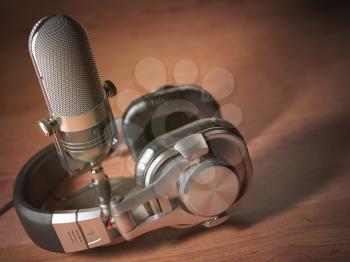 Microphone and headphones on the wooden table. Retro vintage style background. Radio concept. 3d illustration