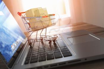 Shopping online and e-commerce. Laptop and shopping cart with boxes on laptop keyboard, 3d illustration