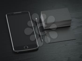 Mockup of blck blank business cards,  black mobile phone and pen on  the black wooden desk background. 3d illustration