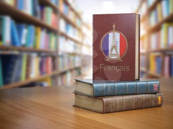 Learn French concept. French dictionary book or textbok with flag of France and Eiffel tower on the cover in the library. 3d illustration