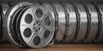 Video, cinema, movie, multimedia concept. A row of vintage film reel or  film spools with filmstrip  3d illustration