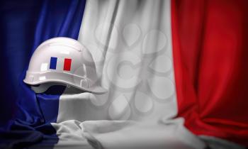 White hard hat laying over french  flag. Construction and employment in France concept,  3d illustration
