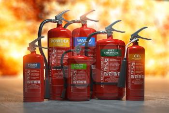 Fire extinguishers on a fire background. Various types and different sizes of extinguishers.
